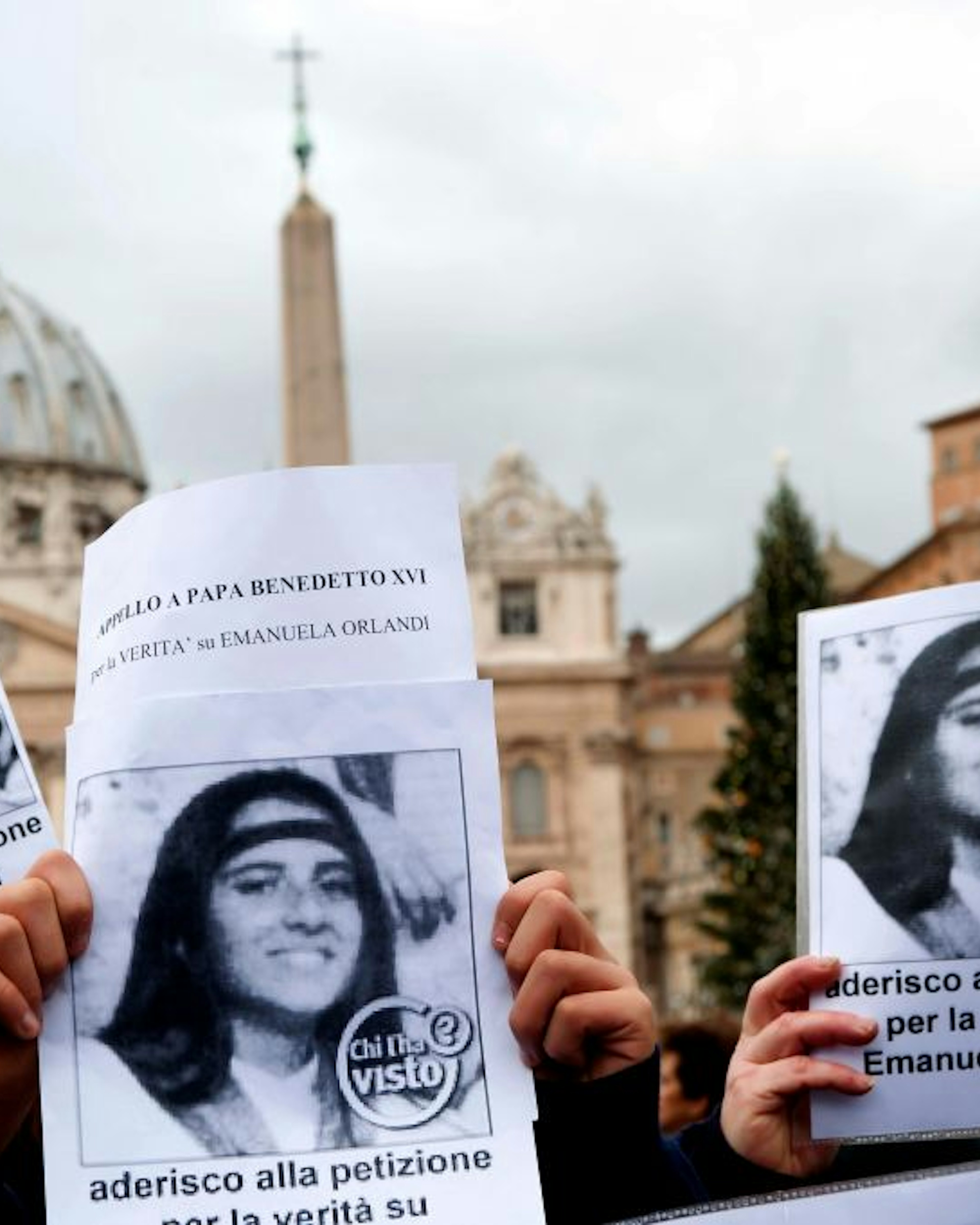 ROME, ITALY - DECEMBER 18: Demonstrators with Emanuela Orlandi's photo in the background St. Peter's Basilica during the Silent demonstration from Castel Sant'Angelo to St. Peter's Square to shed light on the kidnapping of Emanuela Orlandi who disappeared 29 years ago, and to recall the petition launched to Pope Benedict XVI to demand the truth, which has reached 40 thousand adhesions. The event was organised by Pietro Orlandi, Emanuela's brother.on December 18, 2011 in Rome, Italy. Emanuela Orlandi; daughter of a clerk of the pontifical prefecture, the girl, 15 years old, suddenly disappeared on June 22nd 1983 and she's never been found. (Photo by Stefano Montesi - Corbis/Corbis via Getty Images)