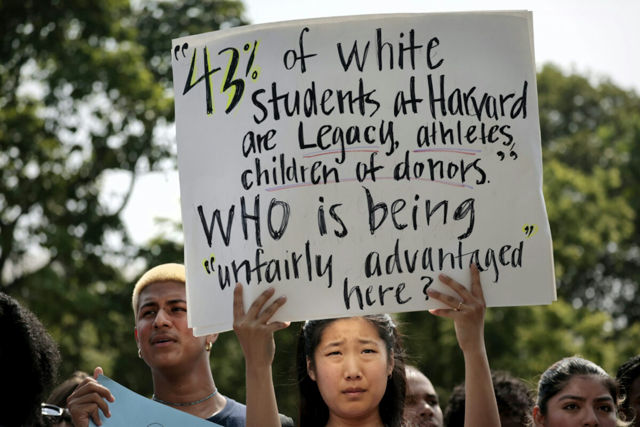 Cambridge, MA - July 1: A Harvard student holds a sign during a rally protesting the Supreme Courts ruling against affirmative action.