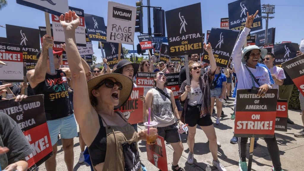 OS ANGELES, CALIFORNIA - JULY 14: Members of the Hollywood actors SAG-AFTRA union walk a picket line with screen writers outside of Paramount Studios on the first day of the actors’ strike which piles on top of the Hollywood writers WGA union strike, now in the 11th week, on July 14, 2023 in Los Angeles, California.