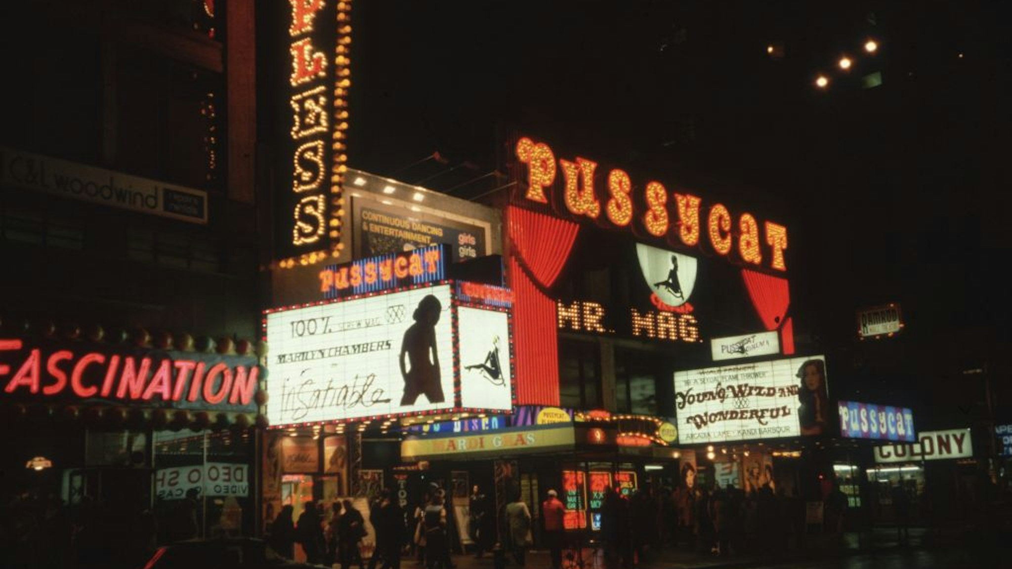 1980: Exterior nighttime view of the Pussycat, an X-rated movie theater on 42nd Street in Times Square, New York City. The marquee advertises porn actor Marilyn Chambers in director Stu Segall's film, 'Insatiable.' (Photo by David Herman/Hulton Archive/Getty Images)