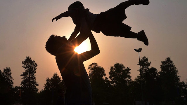 Indian father Shailesh throws up his son, Harish, at a park in Amritsar on June 19, 2016, on Father's Day, a day observed in many countries to celebrate fathers and fatherhood. / AFP / NARINDER NANU (Photo credit should read NARINDER NANU/AFP via Getty Images)