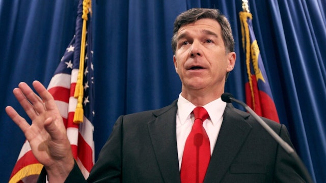 North Carolina Attorney General Roy Cooper, a Democrat, has condemned his state's Republican-sponsored voter ID law and constitutional amendment to ban same-sex marriage. But in his position he must defend the state against lawsuits on both issues.