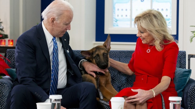 US President Joe Biden and US First Lady Jill Biden, look at their new dog Commander, after speaking virtually with military service members to thank them for their service and wish them a Merry Christmas, from the South Court Auditorium of the White House in Washington, DC, on December 25, 2021.