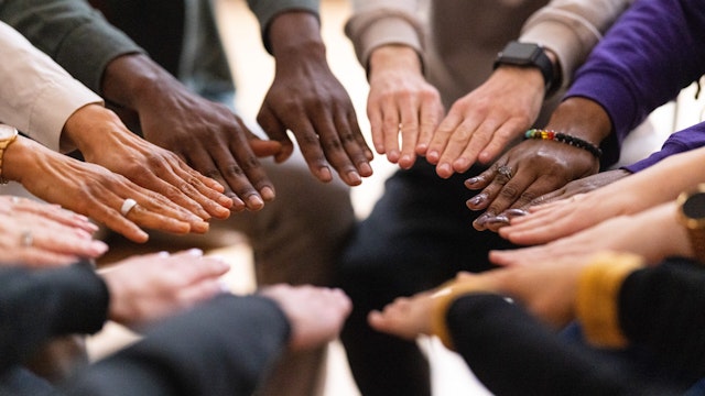 Cropped shot of support group putting their hands together in circle. Multiracial men and women with their hands placed in a circle symbolize unity and support during therapy session.