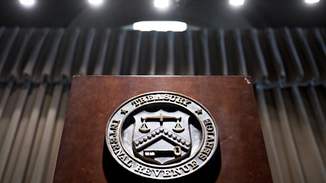 The seal of the Internal Revenue Service (IRS) hangs on a podium during an IRS Criminal Investigation 100th year anniversary event at the agency's headquarters in Washington, D.C., U.S., on Monday, July 1, 2019. On July 1, 1919, the IRS commissioner crated the Intelligence Unit to investigate widespread allegations of tax fraud.