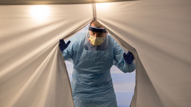 SEATTLE, WASHINGTON - MARCH 13: A nurse wearing protective clothing emerges from a tent a a coronavirus testing center at the University of Washington Medical center on March 13, 2020 in Seattle, Washington. UW Medical staff feeling potential symptoms of COVID-19 were asked to pass through a drive-through screening center on campus for testing. (Photo by John Moore/Getty Images)
