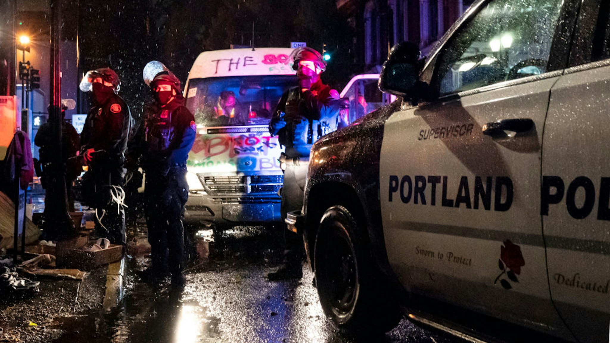 PORTLAND, OR - OCTOBER 11: Police detain passengers in a mutual aid van during an Indigenous Peoples Day of Rage protest on October 11, 2020 in Portland, Oregon. Protesters tore down statues of two U.S. presidents and broke windows out of downtown businesses Sunday night before police intervened. (Photo by Nathan Howard/Getty Images)