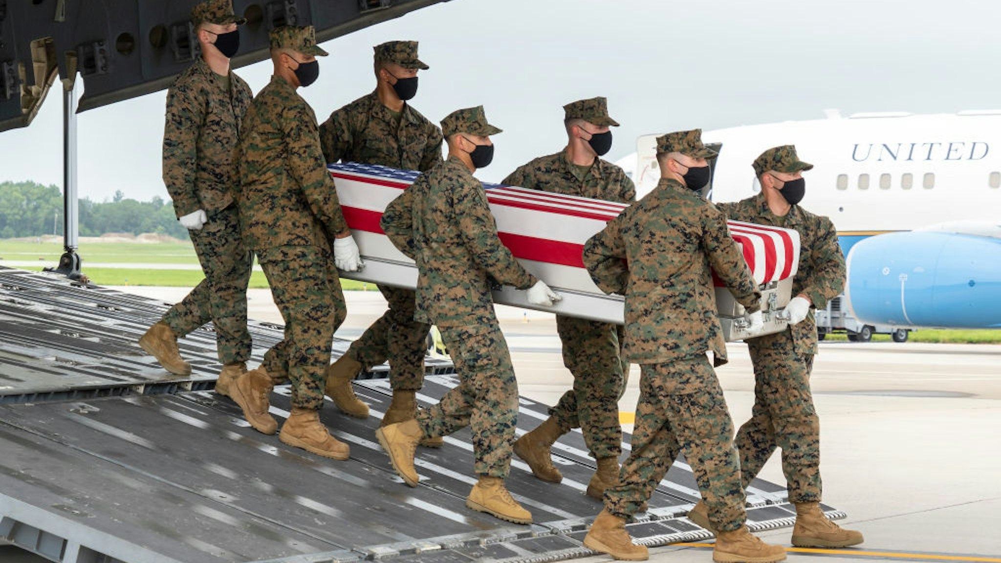 DOVER, DELAWARE - AUGUST 29: In this handout photo provided by the U.S. Air Force, a U.S. Marine Corps carry team transfers the remains of Marine Corps Lance Cpl. Dylan R. Merola of Rancho Cucamonga, California, Aug. 29, 2021 at Dover Air Force Base, Delaware. Merola was assigned to 2nd Battalion, 1st Marine Regiment, 1st Marine Division, I Marine Expeditionary Force, Camp Pendleton, California. (Photo by Jason Minto/U.S. Air Force via Getty Images)