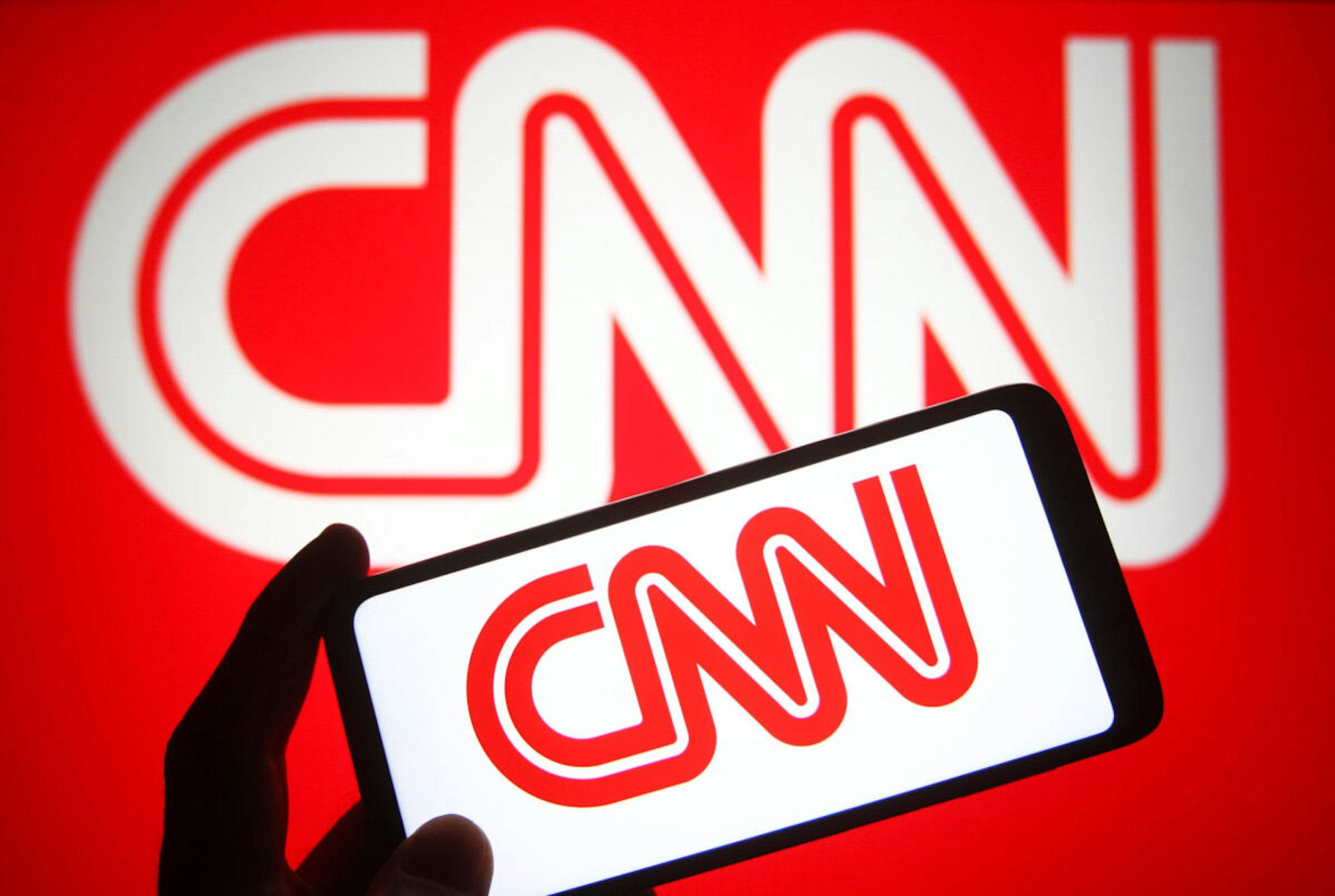 UKRAINE - 2021/10/23: In this photo illustration a CNN (Cable News Network) logo is seen on a smartphone and a pc screen.