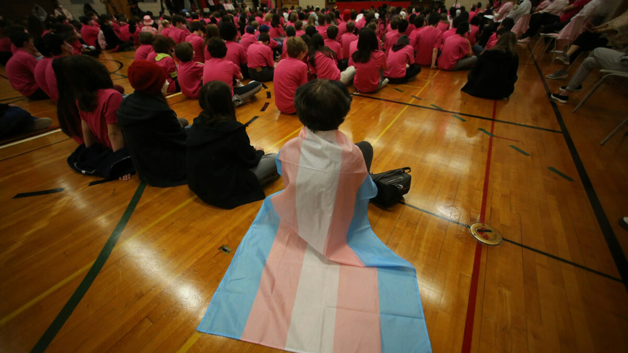 TORONTO, ON- APRIL 13 - A student wears a trans flag during an assembly at Bowmore Road Junior and Senior Public School celebrates International Day of Pink, aimed at building a more inclusive and diverse society by encouraging students to stand up against bullying towards their 2SLGBTQIA+ peers. The Toronto District School Board held its first in-person event since the start of the pandemic. in Toronto. April 13, 2022.