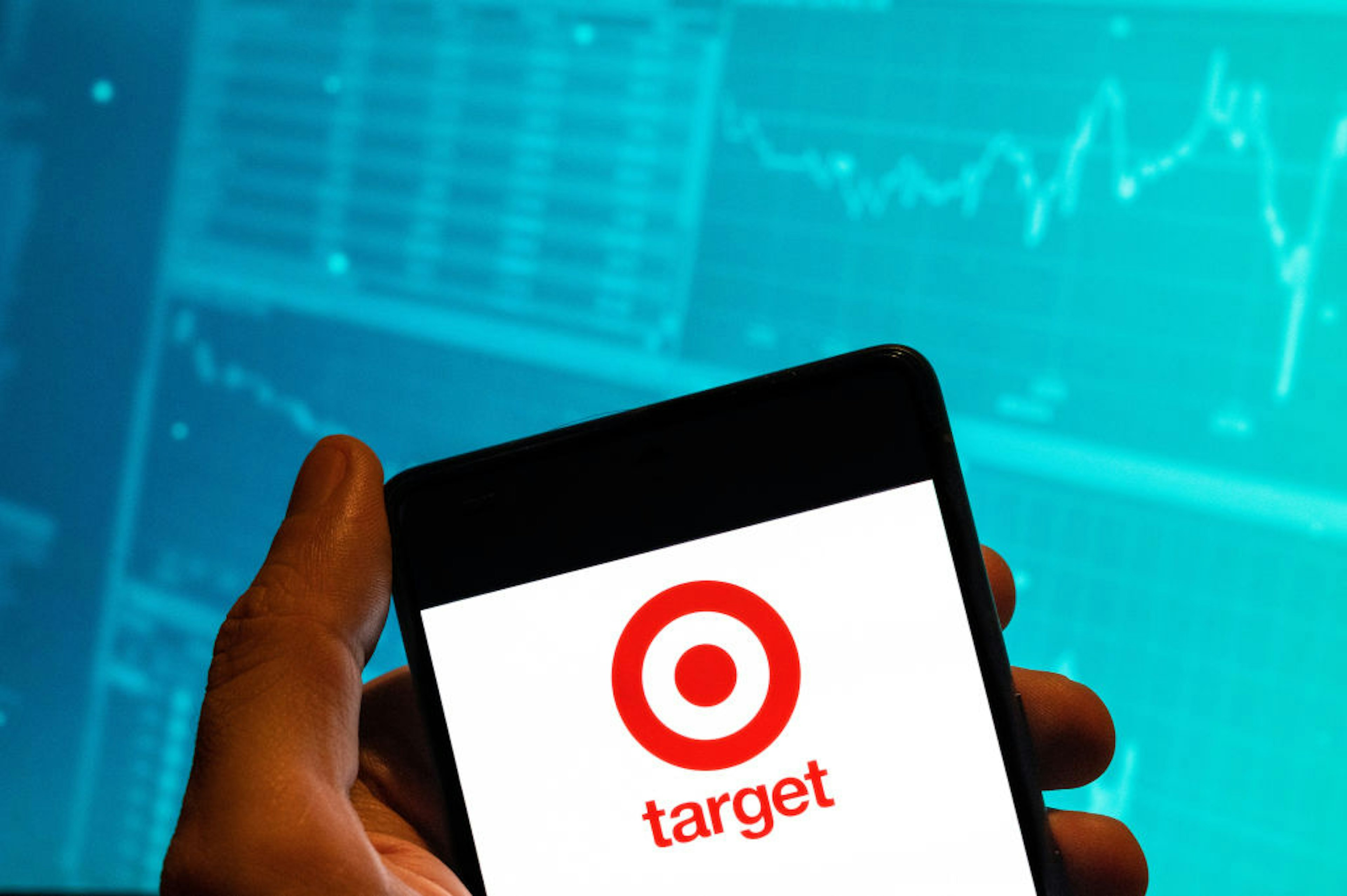CHINA - 2023/02/15: In this photo illustration, the American retail corporation Target logo is seen displayed on a smartphone with an economic stock exchange index graph in the background. (Photo Illustration by Budrul Chukrut/SOPA Images/LightRocket via Getty Images)