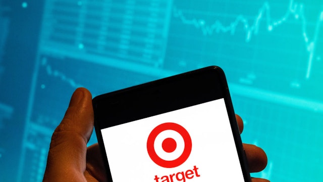 CHINA - 2023/02/15: In this photo illustration, the American retail corporation Target logo is seen displayed on a smartphone with an economic stock exchange index graph in the background. (Photo Illustration by Budrul Chukrut/SOPA Images/LightRocket via Getty Images)