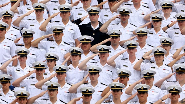 ANNAPOLIS, MARYLAND - MAY 27: Midshipmen salute during the performance of the national anthem during the graduation and commissioning ceremony at the U.S. Naval Academy Memorial Stadium on May 27, 2022 in Annapolis, Maryland. Biden delivered the keynote address to the A total of 1,100 sailors and Marines who graduated from the service academy. (Photo by Chip Somodevilla/Getty Images)