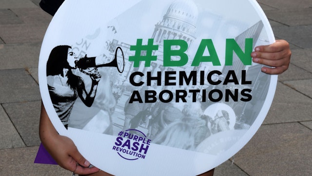 WASHINGTON, DC - JUNE 28: An anti-abortion activist holds a sign as she participates in a "#BanChemicalAbortions" protest outside of the Department of Health and Human Services (HHS) June 28, 2022 in Washington, DC. The Stanton Public Policy Center, Purple Sash Revolution and Created Equal held a protest "calling for a ban on chemical abortions."