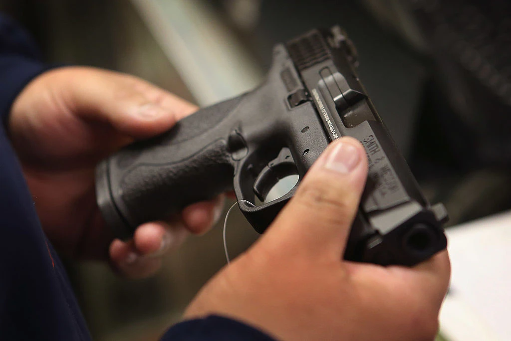 TINLEY PARK, IL - DECEMBER 17: A customer shops for a pistol at Freddie Bear Sports sporting goods store on December 17, 2012 in Tinley Park, Illinois. Americans purchased a record number of guns in 2012 and gun makers have reported a record high in demand. Firearm sales have surged recently as speculation of stricter gun laws and a re-instatement of the assault weapons ban following the mass school shooting in Connecticut . (Photo by Scott Olson/Getty Images)