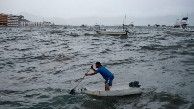 A man rows his boat in Acapulco, Guerrero State, Mexico, on August 16, 2023, following the passage of Tropical Storm Hilary.