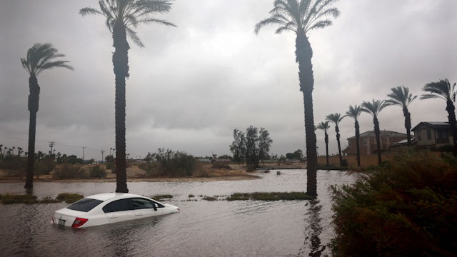 CATHEDRAL CITY, CALIFORNIA - AUGUST 20: A car is partially submerged in floodwaters as Tropical Storm Hilary moves through the area on August 20, 2023 in Cathedral City, California. Southern California is under a first-ever tropical storm warning as Hilary impacts parts of California, Arizona and Nevada. All California state beaches have been closed in San Diego and Orange counties in preparation for the impacts from the storm which was downgraded from hurricane status.