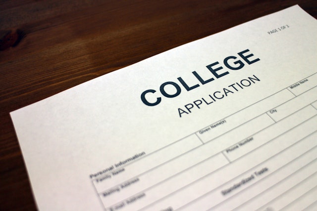 Hailshadow. Getty Images. Someone filling out College Application