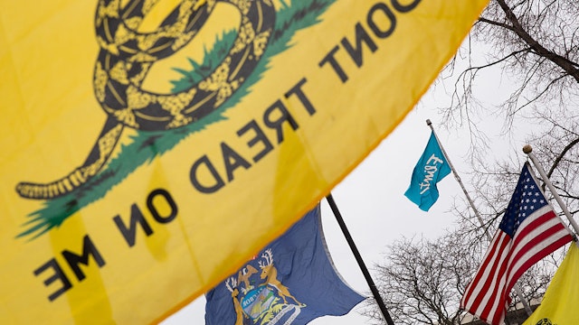 FLINT, MI - JANUARY 24: Gadsden flags surround Flint, Michigan and United States flags during a rally on January 24, 2016 at Flint City Hall in Flint, Michigan. The event was organized by Genesee County Volunteer Militia to protest corruption they see in government related to the Flint water crisis that resulted in a federal state of emergency.