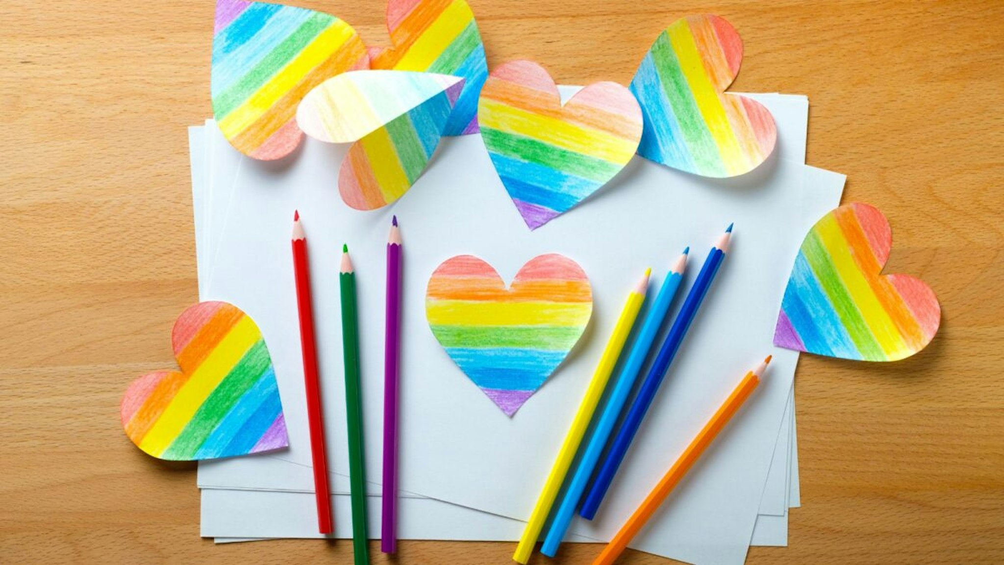 The heart is carved and drawn on white paper and painted in the color of the LGBT flag.