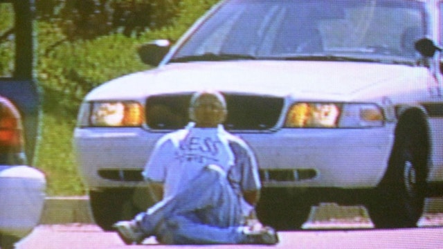 Brian Wells sits surrounded by police cars with the collar bomb locked to his neck.(Supplied: Erie Bureau of Police)