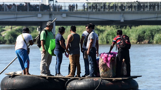 Honduran migrants heading in a caravan to de US, cross the Suchiate River, natural border between Guatemala and Mexico, in makeshift rafts, in Ciudad Tecun Uman, Guatemala, on October 22, 2018. - President Donald Trump on Monday called the migrant caravan heading toward the US-Mexico border a national emergency, saying he has alerted the US border patrol and military. (Photo by ORLANDO SIERRA / AFP)