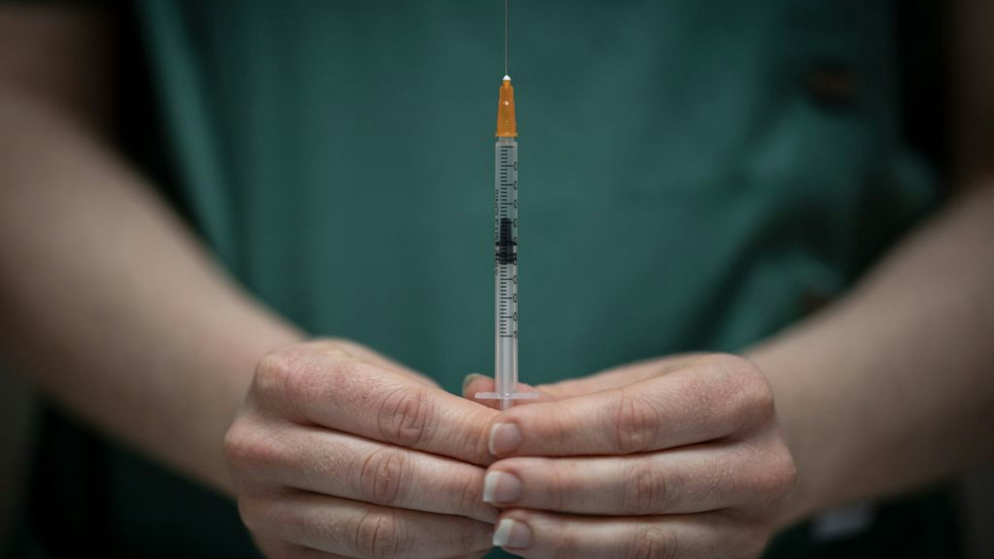 A pharmacist prepares a dose of the AstraZeneca/Oxford Covid-19 vaccine with a syringe in a pharmacy, in Savenay, western France, on April 2, 2021. (Photo by LOIC VENANCE / AFP) (Photo by LOIC VENANCE/AFP via Getty Images)
