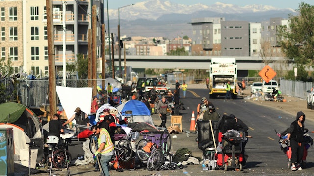 DENVER, COLORADO - MAY 17: People exercising homelessness gather belonging as crews work to cleanup a homeless camp in the RiNo neighborhood near the Platte River on May 17, 2022 in Denver, Colorado.(Photo by RJ Sangosti/MediaNews Group/The Denver Post via Getty Images)"n"n