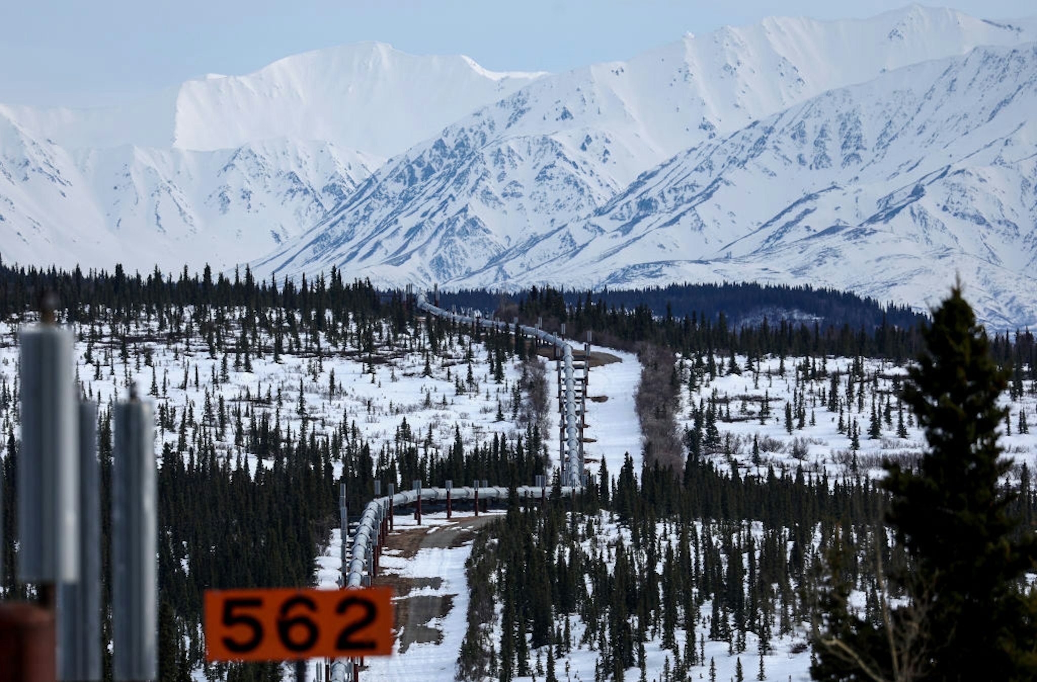 DELTA JUNCTION, ALASKA - MAY 05: A part of the Trans Alaska Pipeline System runs through boreal forest past Alaska Range mountains on May 5, 2023 near Delta Junction, Alaska. The 800-mile-long pipeline carries oil from the North Slope in Prudhoe Bay to the port of Valdez. In March, the Biden administration approved the controversial Willow project which will extract 600 million barrels of oil from the National Petroleum Reserve on Alaska’s North Slope, close to the Arctic Ocean.