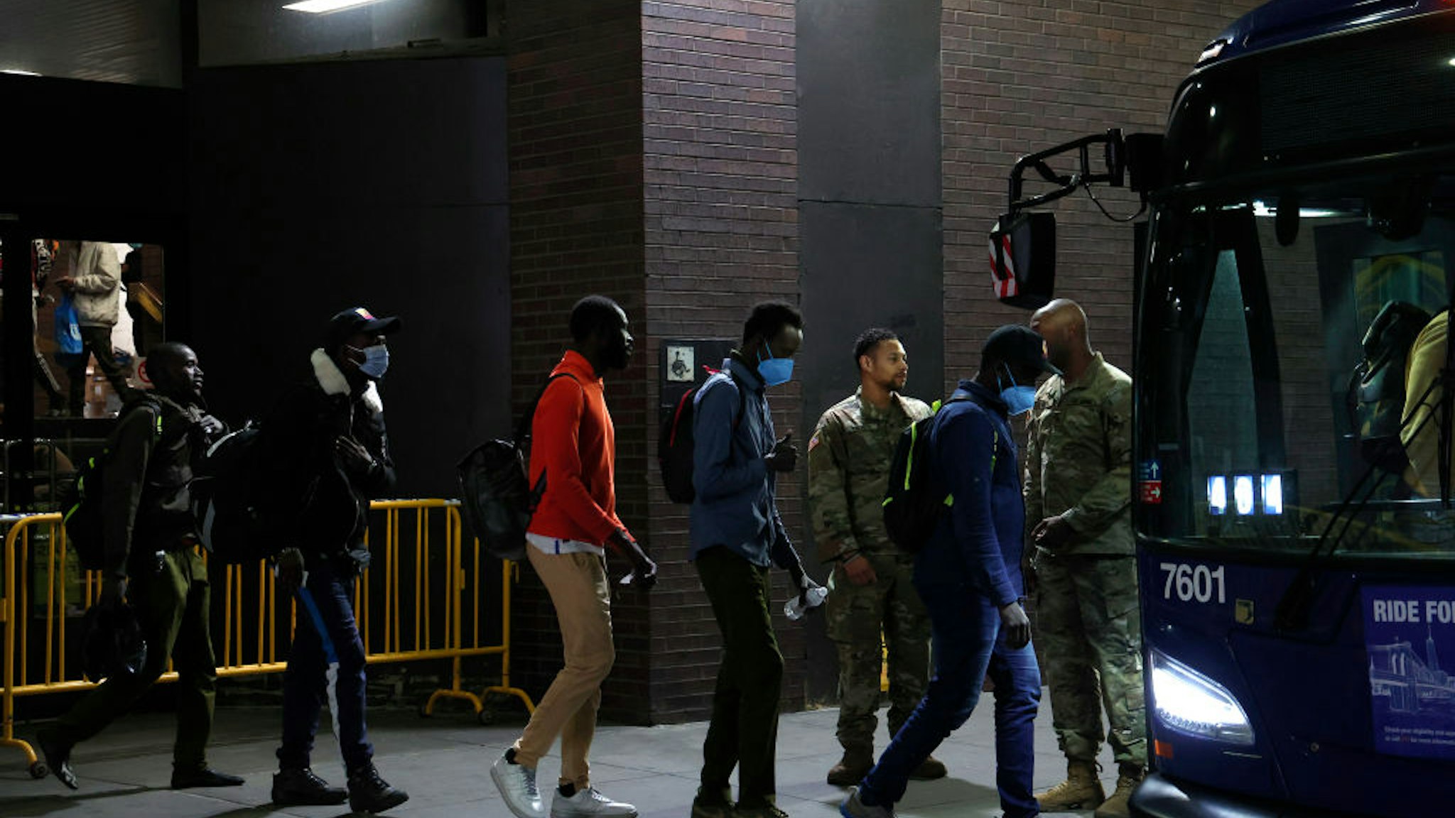 NEW YORK, NEW YORK - MAY 15: US military personnel keep watch as asylum seekers are transferred via city bus from Port Authority bus terminal to housing facilities in the Bronx and Queens on May 15, 2023 in New York City. After arriving from the Texas/Mexico border and being processed by New York City officials, the migrants are sent to various housing facilities around the NYC boroughs. In the coming days the Roosevelt Hotel will initially provide a limited number of beds and later function as a welcome and support center for the migrants. (Photo by John Lamparski/Getty Images)