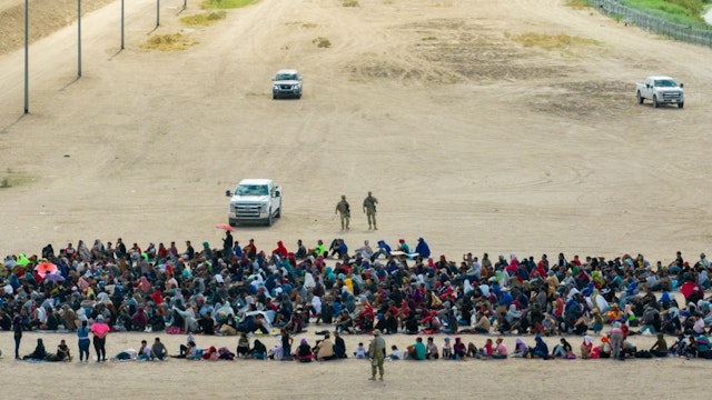 EL PASO, TEXAS - SEPTEMBER 21: In an aerial view, migrants are seen grouped together while waiting to be processed on the Ciudad Juarez side of the border on September 21, 2023 in El Paso, Texas. A recent surge of migrant crossings have occurred along the Southwestern region of the United States border. (Photo by Brandon Bell/Getty Images)