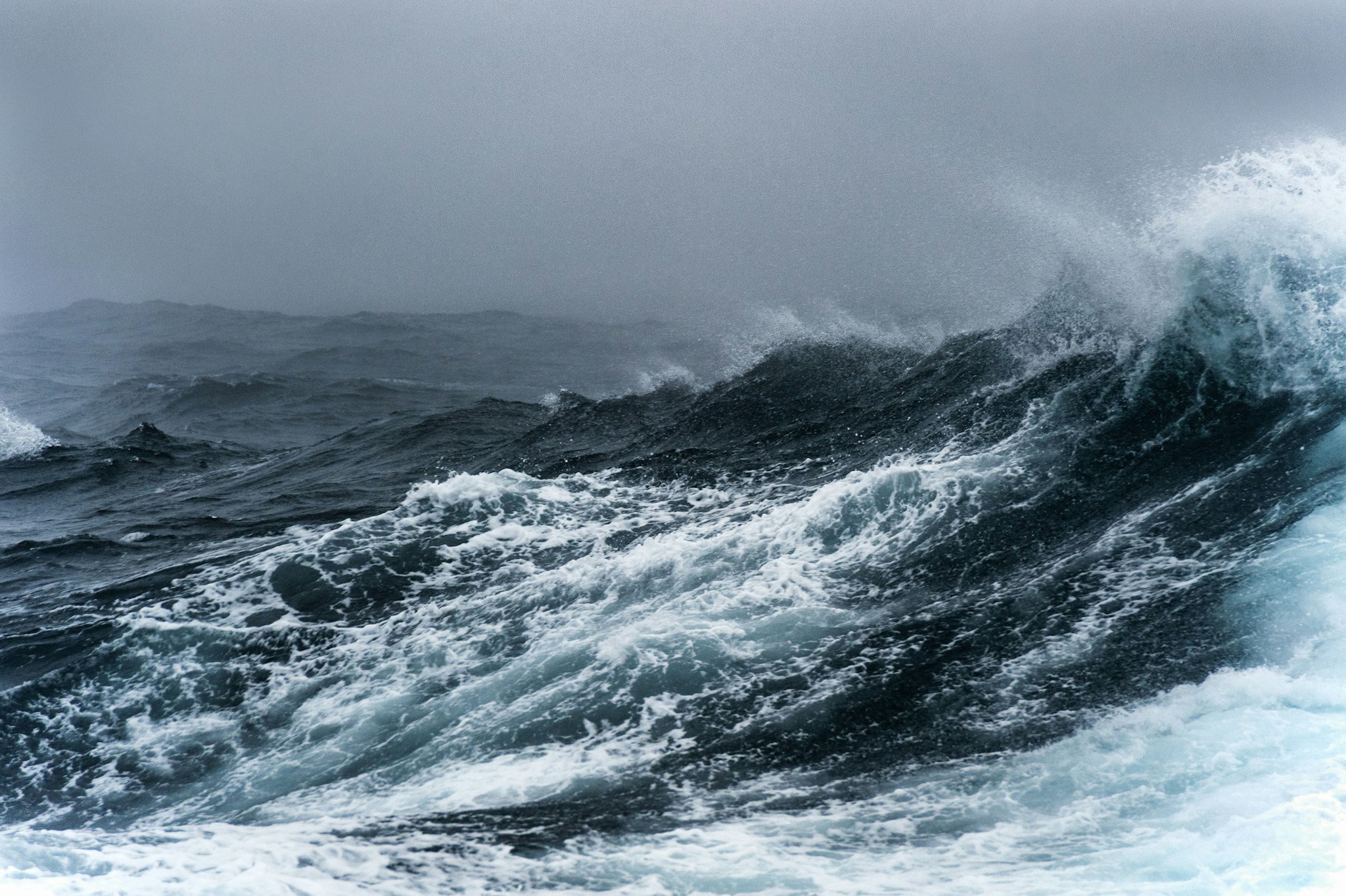 Breaking wave on a rough sea against overcast sky, Southern Ocean.