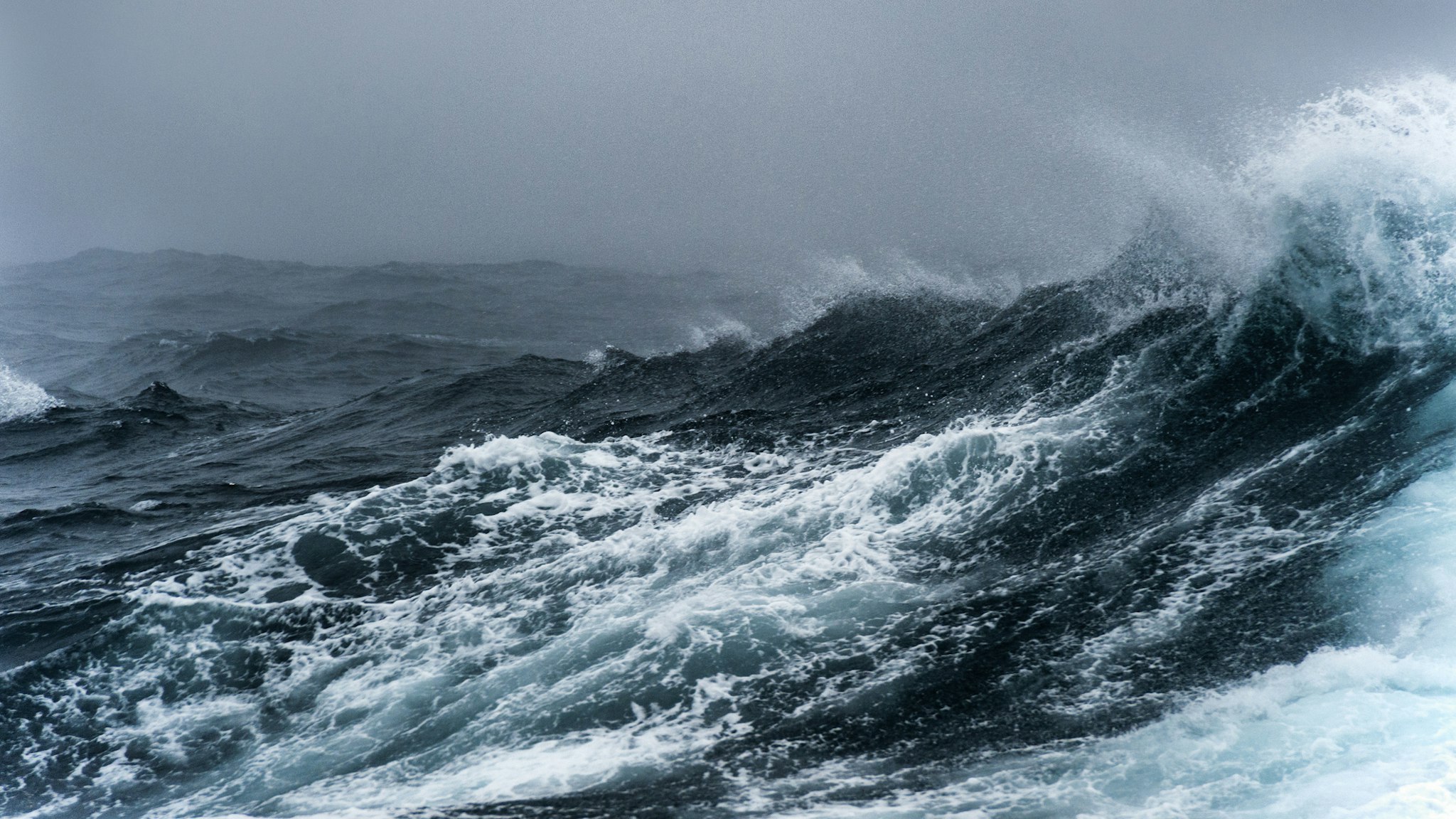 Breaking wave on a rough sea against overcast sky, Southern Ocean.