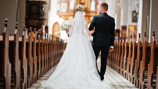 ASphotowed. Getty Images. Photosession of stylish wedding couple on catholic church.