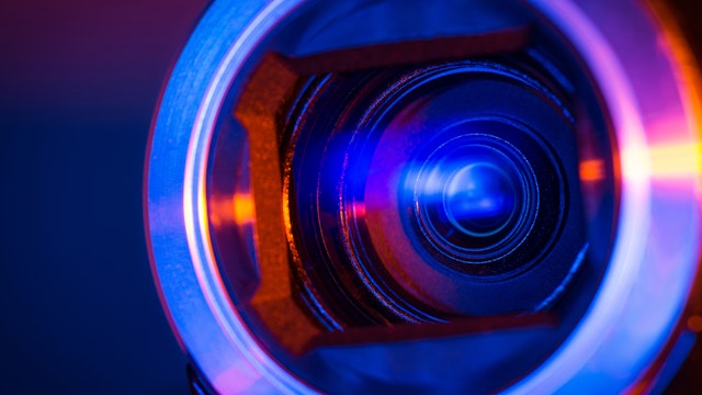 Denniro. Getty Images. Video camera lens lit by different color light sources
