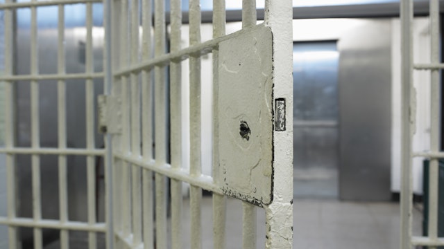 Open door to prison cell - stock photo