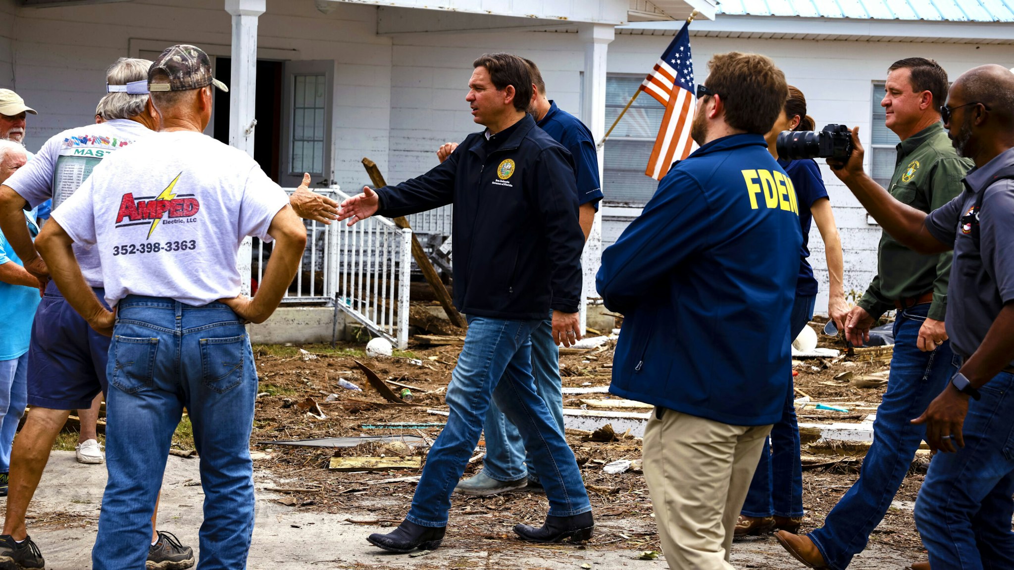 Ron DeSantis, governor of Florida and 2024 Republican presidential candidate, center, shakes hands with residents during a visit after Hurricane Idalia in Horseshoe Beach, Florida, US, on Thursday, Aug. 31, 2023. Florida has started to dig out from the aftermath of Idalia, which weakened to a tropical storm even as it brought heavy rain across Georgia and the Carolinas, caused billions of dollars in damage, left hundreds of flights grounded and thousands without power.