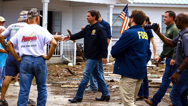 Ron DeSantis, governor of Florida and 2024 Republican presidential candidate, center, shakes hands with residents during a visit after Hurricane Idalia in Horseshoe Beach, Florida, US, on Thursday, Aug. 31, 2023. Florida has started to dig out from the aftermath of Idalia, which weakened to a tropical storm even as it brought heavy rain across Georgia and the Carolinas, caused billions of dollars in damage, left hundreds of flights grounded and thousands without power.
