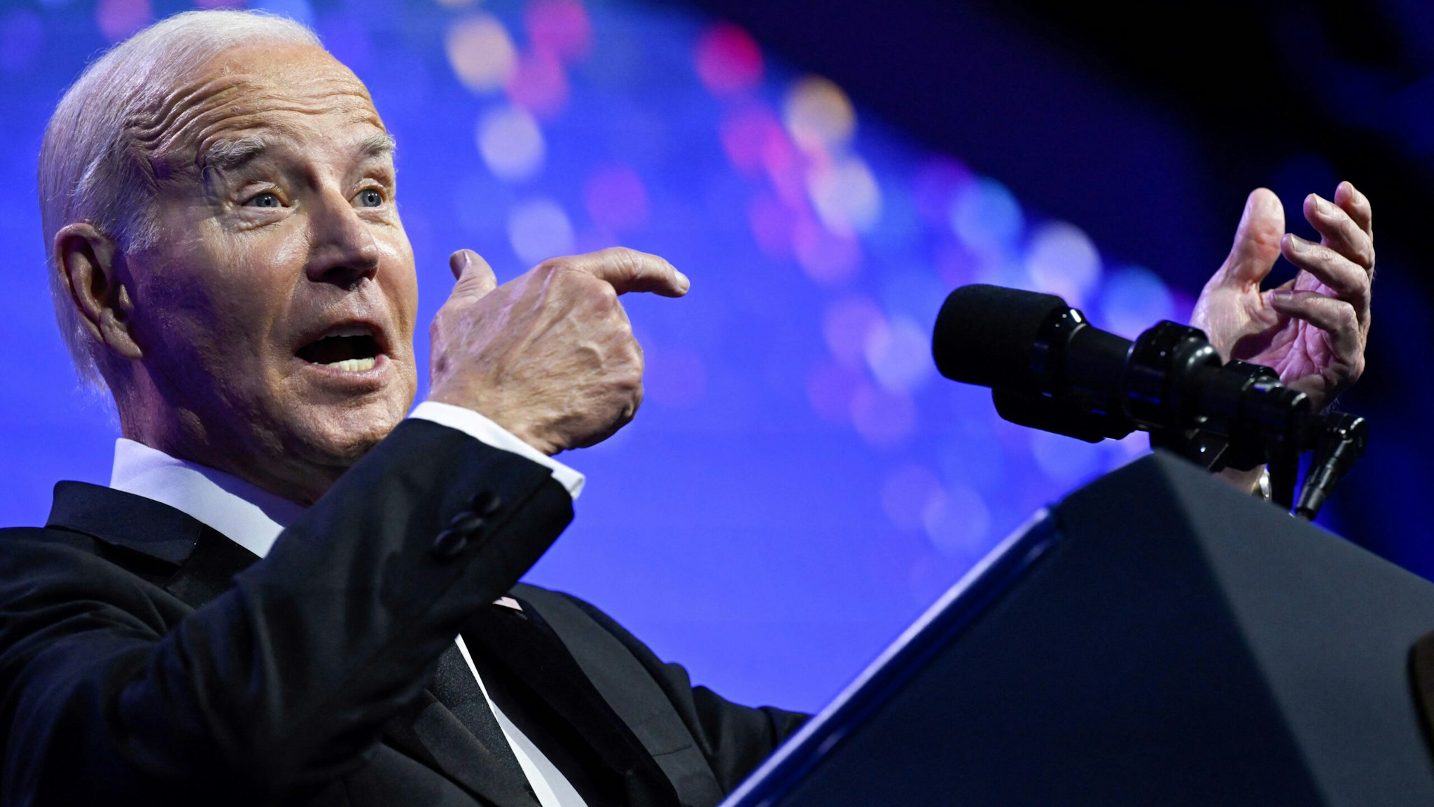 US President Joe Biden mimics holding a firearm while speaking about assault weapon ban during the Human Rights Campaign National Dinner at the Washington Convention Center in Washington, DC, on October 14, 2023.