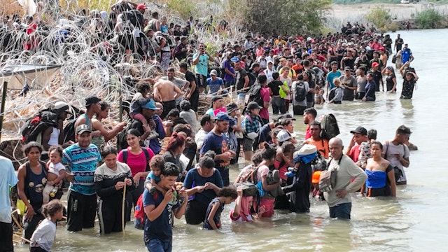 Eagle Pass, Texas, Monday, September 25, 2023 - Hundreds of people wait for hours to pass through razor wire along the banks of the Rio Grande near the Camino Real International Bride. (Robert Gauthier/Los Angeles Times via Getty Images)