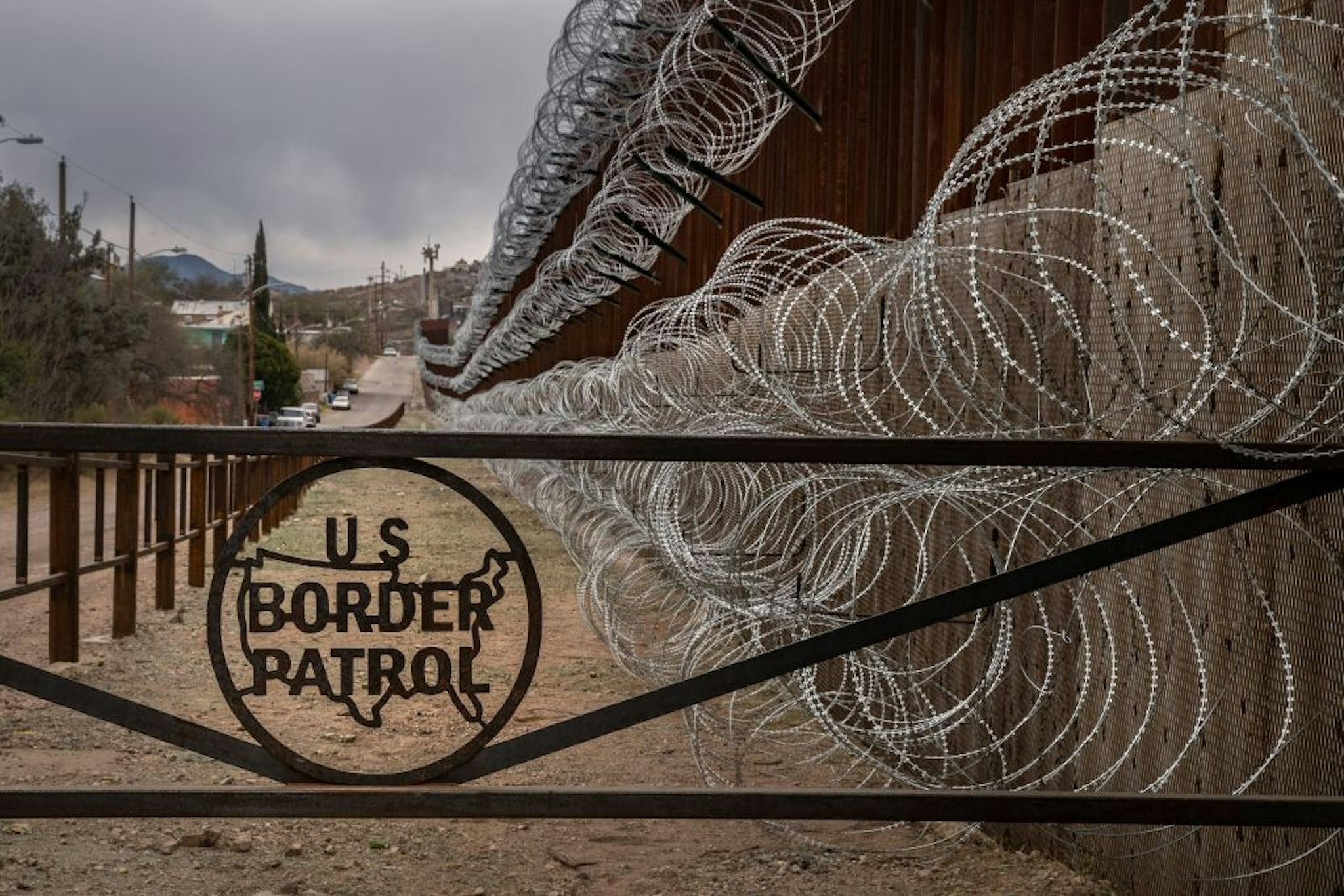 TOPSHOT - A metal fence marked with the US Border Patrol sign prevents people to get close to the barbed/concertina wire covering the US/Mexico border fence, in Nogales, Arizona, on February 9, 2019. (Photo by Ariana Drehsler / AFP) (