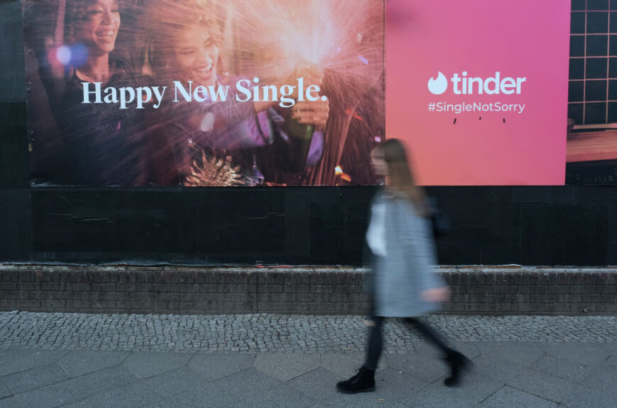 BERLIN, GERMANY - FEBRUARY 18: A young woman walks past a billboard advertisement for the dating app Tinder on February 18, 2019 in Berlin, Germany. Tinder has emerged as one of the most popular dating apps. (Photo by Sean Gallup/Getty Images)