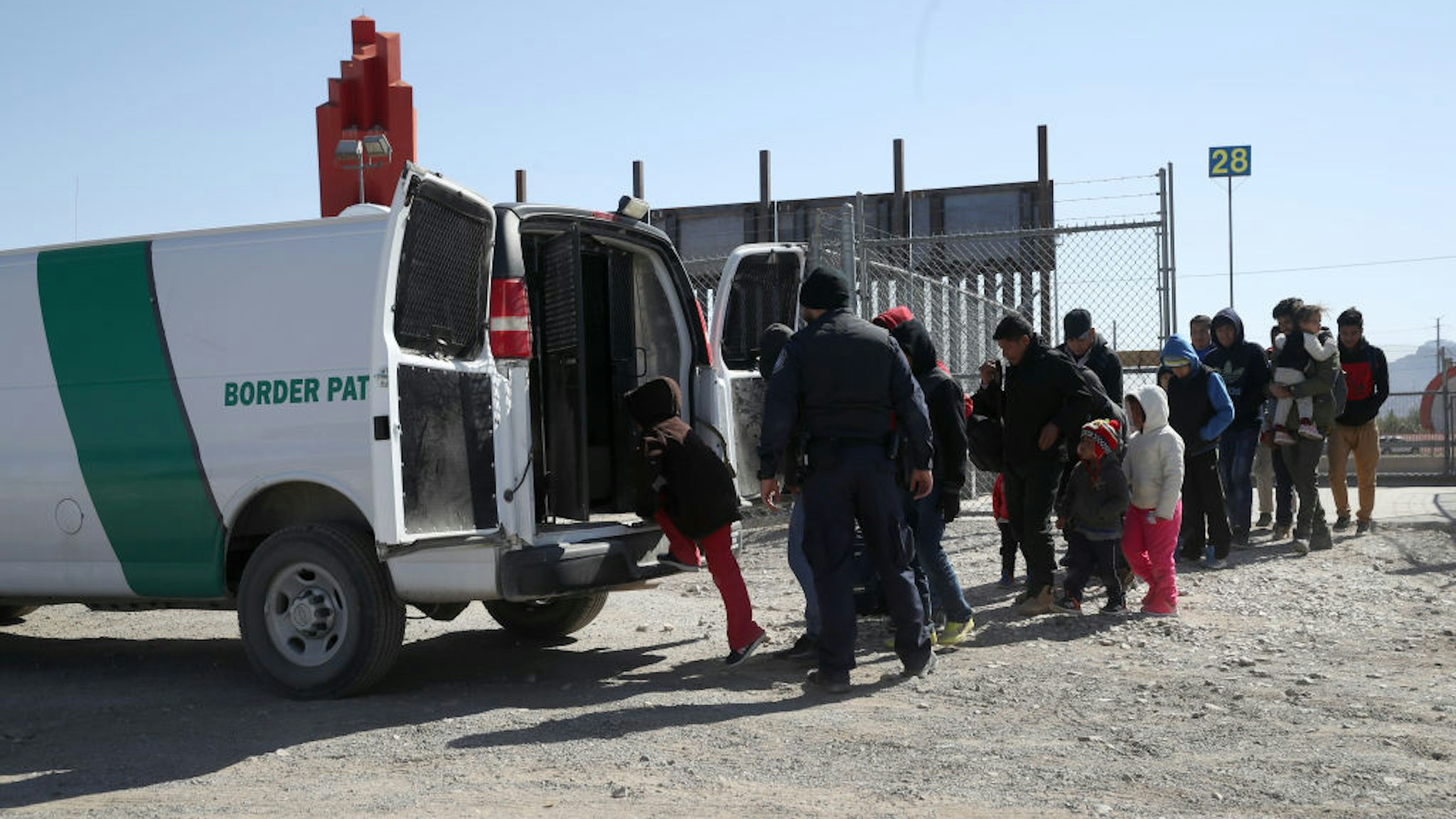 EL PASO, - MARCH 31: A U.S. Border Patrol agent loads detained migrants into a van at the border of the United States and Mexico on March 31, 2019 in El Paso, Texas. U.S. President Donald Trump has threatened to close the United States border if Mexico does not stem the flow of illegal migrants trying to cross.