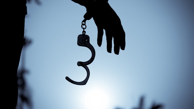 Cropped Hand Of Men Removing Handcuffs - stock photo