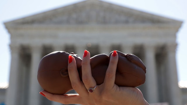 WASHINGTON, DC - JUNE 29: A pro-life activist holds a model fetus during a demonstration in front of the U.S. Supreme Court June 29, 2020 in Washington, DC. The Supreme Court has ruled today, in a 5-4 decision, a Louisiana law that required abortion doctors need admitting privileges to nearby hospitals unconstitutional.