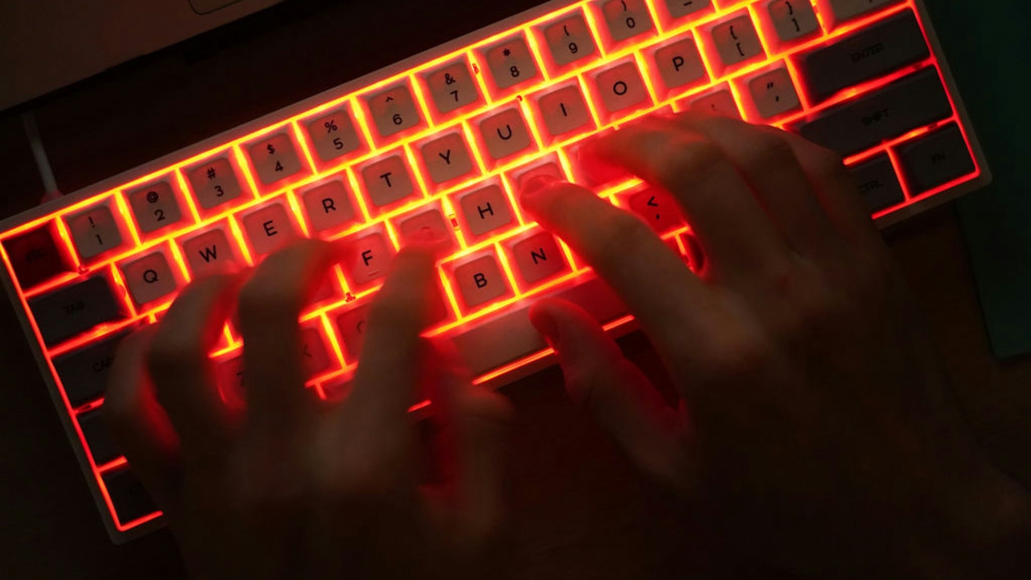 BERLIN, GERMANY - JANUARY 25: In this photo illustration a young man types on an illuminated computer keyboard typically favored by computer coders on January 25, 2021 in Berlin, Germany. 2020 saw a sharp rise in global cybercrime that was in part driven by the jump in online retailing that ensued during national lockdowns as governments sought to rein in the coronavirus pandemic. (Photo by Sean Gallup/Getty Images)