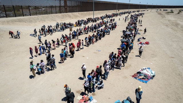 EL PASO, TEXAS - MAY 11: In an aerial view, immigrants line up to be processed to make asylum claims at a makeshift migrant camp on May 11, 2023 in El Paso, Texas. The number of immigrants reaching the border has surged with the end of the U.S. government's Covid-era Title 42 policy, which for the past three years has allowed for the quick expulsion of irregular migrants entering the country. (Photo by John Moore/Getty Images)