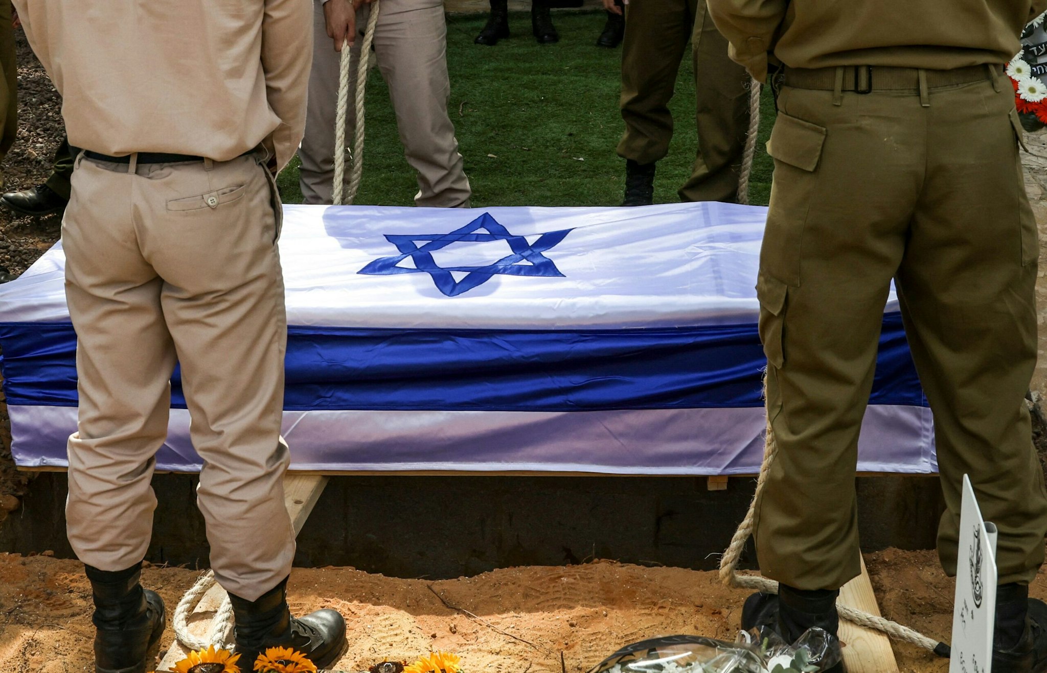 Soldiers lower the casket of French-Israeli soldier Eli Valentin Ghenassia, who was killed in combat at Kibbutz Beeri during an infiltration by Hamas militans, during his funeral in the Mount Herzl cemetery in Jerusalem on October 12, 2023. Thousands of people, both Israeli and Palestinian, have died since October 7, after Palestinian Hamas militants entered Israel in a surprise attack leading Israel to declare war on Hamas in the Gaza Strip enclave.