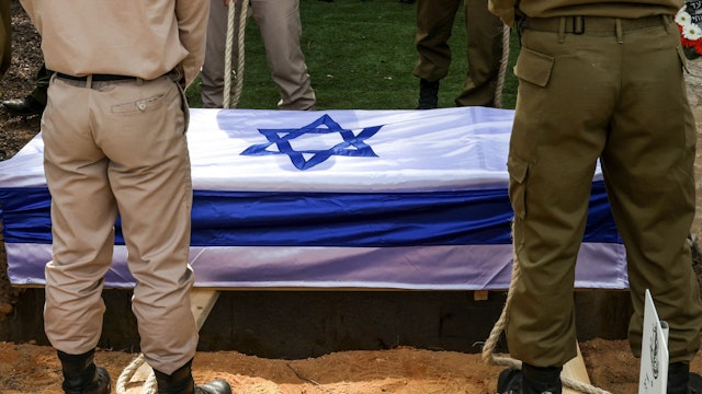Soldiers lower the casket of French-Israeli soldier Eli Valentin Ghenassia, who was killed in combat at Kibbutz Beeri during an infiltration by Hamas militans, during his funeral in the Mount Herzl cemetery in Jerusalem on October 12, 2023. Thousands of people, both Israeli and Palestinian, have died since October 7, after Palestinian Hamas militants entered Israel in a surprise attack leading Israel to declare war on Hamas in the Gaza Strip enclave.