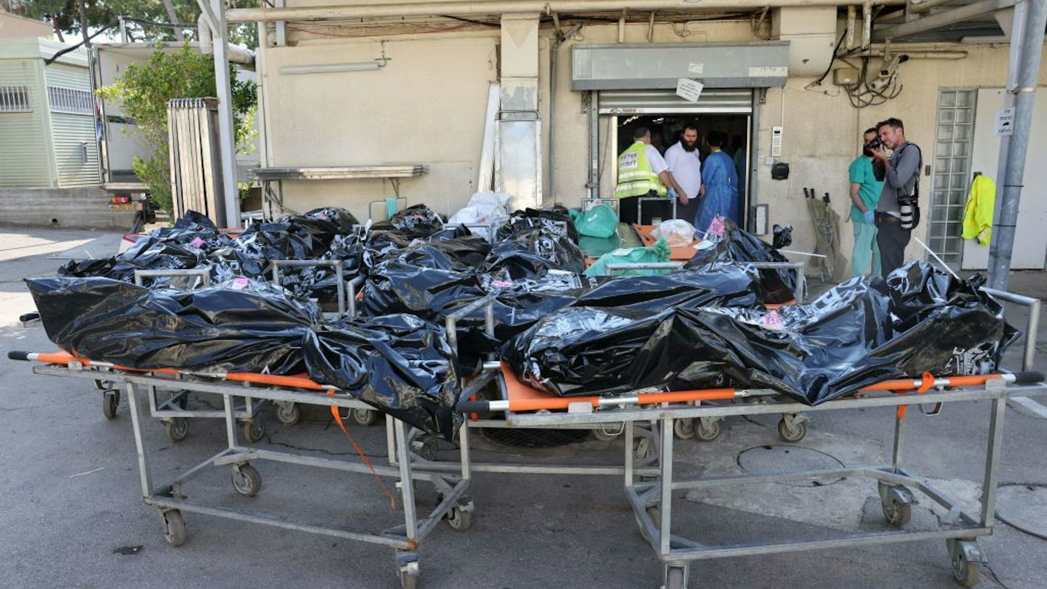 Bodies of people killed in the attack by Gaza-based Hamas militants on southern Israel await identification outside the National Center for Forensic Medicine in Tel Aviv on October 16, 2023. (Photo by AHMAD GHARABLI / AFP) (Photo by AHMAD GHARABLI/AFP via Getty Images)
